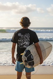 Person holding a surfboard on a beach with ocean waves in the background